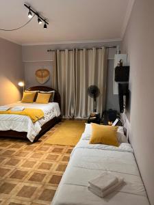 a bedroom with two beds with yellow pillows at Studio Central na Amadora, Vista da Cidade, Sossegado, a 15min de Lisboa in Amadora