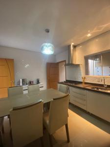 a kitchen with a dining room table and chairs at Royal Lion Bedroom in Londrina +19 photos