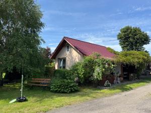a small house with a bench and a tree at Bokaczówka in Ustka