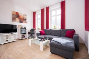 a living room with a couch and a tv at Hotel Garni Ammergauer Hof in Oberammergau