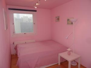una camera rosa con letto e finestra di Flat UNO City a Vienna