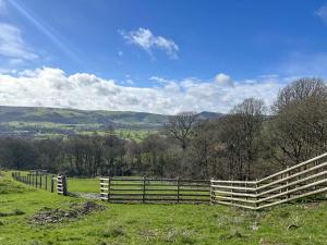 a wooden fence in a field with trees and hills at Birch Cottage - Ukc9267 in Hope