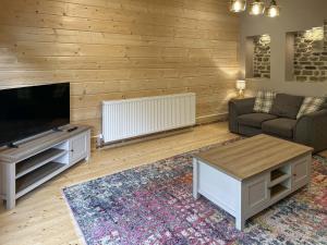 a living room with a couch and a tv at Birch Cottage - Ukc9267 in Hope