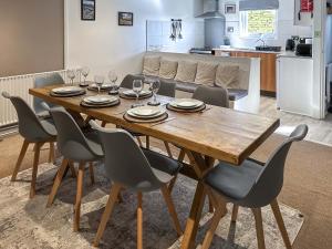 a dining room table with chairs and a kitchen at Birch Cottage - Ukc9267 in Hope +13 photos