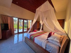 a bedroom with a bed with a mosquito net at Intan Villa & Suite Ubud in Ubud