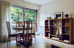 a dining room with a table and chairs and a window at Appt Lakeside - Hossegor centre - Terrasse in Hossegor