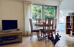 a living room with a table and chairs and a television at Appt Lakeside - Hossegor centre - Terrasse in Hossegor