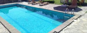 a swimming pool with blue water in a yard at ძველი სახლი Old house in Ureki
