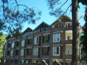 a large brick building with windows and a tree at ძველი სახლი Old house in Ureki