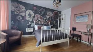 a bedroom with a bed and a wall with flowers at B&B "Villa Fink" in Ostheim