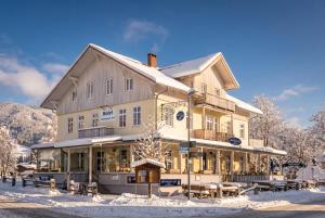 a large building in the snow with tables at Hotel Garni Ammergauer Hof in Oberammergau