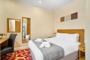 a hotel room with a large bed and a desk at Best Western London Ilford Hotel in Ilford