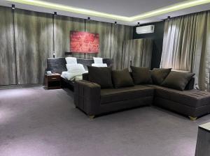 a living room with a couch and a bed at Polo Signature Hotel in Kaduna