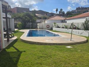 a swimming pool in the yard of a house at Apartamento relax Tauro in Mogán
