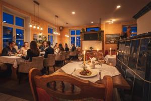 a group of people sitting at tables in a restaurant at Hotel Garni Ammergauer Hof in Oberammergau