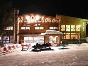 a building with a snowmobile in front of it at night at New Yokote in Yamanouchi