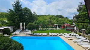 a swimming pool with lounge chairs and a resort at Caprice Monteoru in Sărata-Monteoru