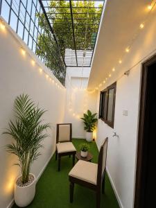 a room with two chairs and a table and a plant at Villa by Stay Junction in Indore
