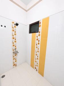 a bathroom with a shower with yellow and white walls at Villa by Stay Junction in Indore