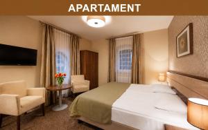 a hotel room with a bed and a table and chairs at Hotel Miodowy Młyn in Opatów +47 photos
