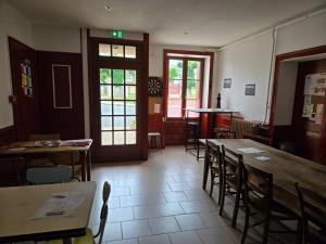 a dining room with tables and chairs and windows at Le Relais d'Heugnes in Heugnes +11 photos
