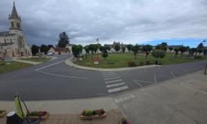 an empty street in a small town with a church at Le Relais d'Heugnes in Heugnes