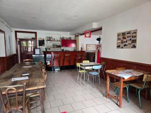 a restaurant with tables and chairs and a kitchen at Le Relais d'Heugnes in Heugnes