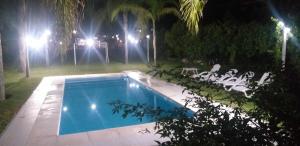 a swimming pool in a yard at night at Cabañas TERMALES in Termas de Río Hondo