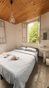 a bedroom with two beds and a sink and a window at Albergo Santa Maria in Esino Lario