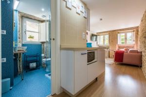 a room with a kitchen and a living room at roomPEDRA apartamentos turísticos in Santiago de Compostela +40 photos