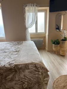 a bedroom with a large bed and two windows at Le nid gourmand in Andryes