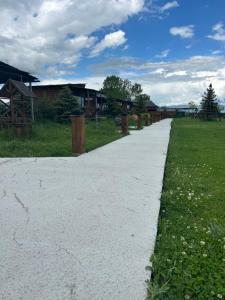 a concrete path in a field with houses in the background at V&V Hotel in Gyulagarak