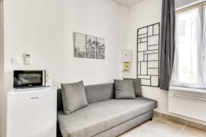 a living room with a couch and a tv at La Petite Maison - Studio in Peyriac-de-Mer