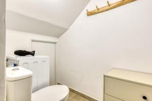 a white bathroom with a toilet and a sink at La Petite Maison - Studio in Peyriac-de-Mer