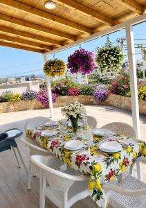 a table with white chairs and flowers on a patio at Villa Murataj in Ksamil