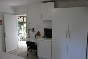 a white room with a desk and a computer at Gender Links Cottages in Johannesburg