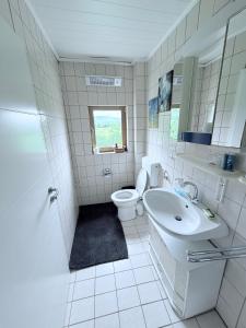 a white bathroom with a toilet and a sink at Ferienwohnung Lebensbaum in Trimberg in Elfershausen