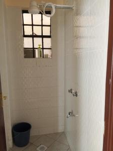 a bathroom with a shower with a window at Halcon Homes Machakos Boma Yangu in Machakos