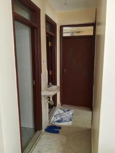 a bathroom with a sink and a toilet and a door at Halcon Homes Machakos Boma Yangu in Machakos