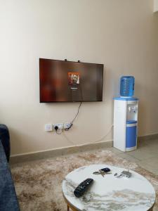 a tv on a wall with a remote control on a table at Halcon Homes Machakos Boma Yangu in Machakos