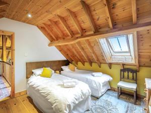 two beds in a room with a wooden ceiling at Seaton Court - Uk31955 in Staithes +35 photos