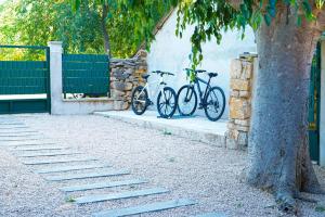 two bikes parked next to a wall next to a tree at Nada Apartment near Krka National Park in Skradin