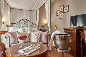 a hotel room with a bed and a table with wine glasses at Relais Osteria Dell'Orcia in Bagno Vignoni