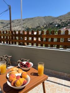 a table with two bowls of fruit and orange juice at La mina's house in Symi +16 photos