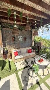 a outdoor patio with a couch and a table at Private Oasis with Jacuzzi & Pool for Two in Ciales