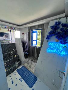 a bathroom with a walk in shower with a blue sign on the wall at Private Oasis with Jacuzzi & Pool for Two in Ciales