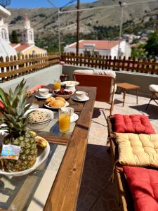 a wooden table with food and drinks on a balcony at La mina's house in Symi