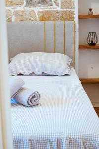 a bed with two pillows and two towels on it at Nada Apartment near Krka National Park in Skradin