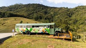a green bus parked on the side of a hill at D'Alma Bus com café da manhã in Pomerode