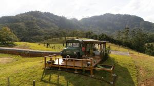a small green vehicle on a road in a field at D'Alma Bus com café da manhã in Pomerode